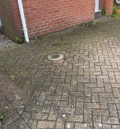 Dirty moss covered driveway needing pressure washing in Norton Canes WS11