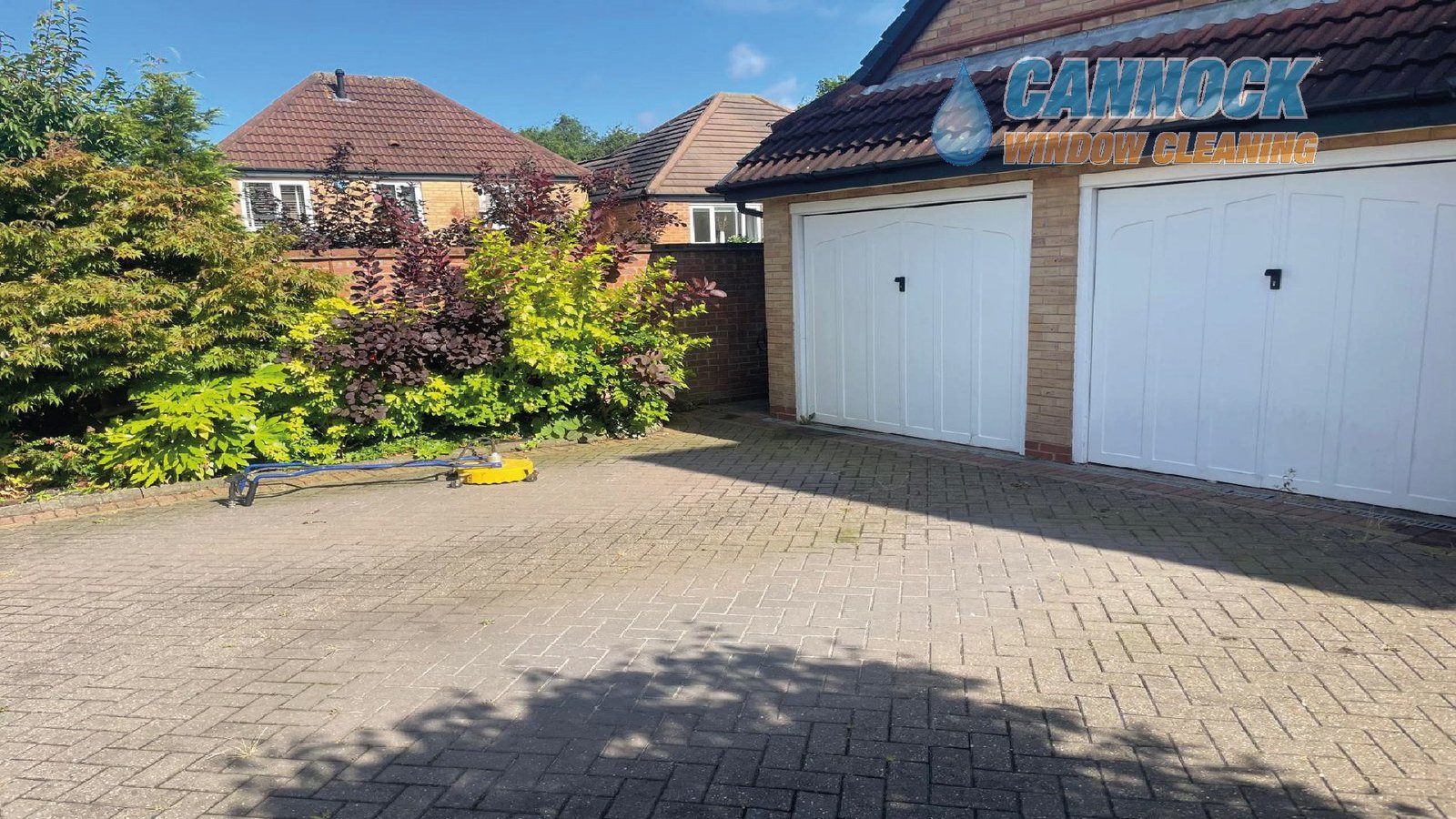 Block paving drive in front of a double garage before cleaning