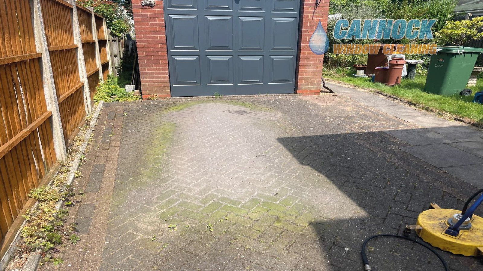 Herringbone drive green with moss in front of a garage before cleaning