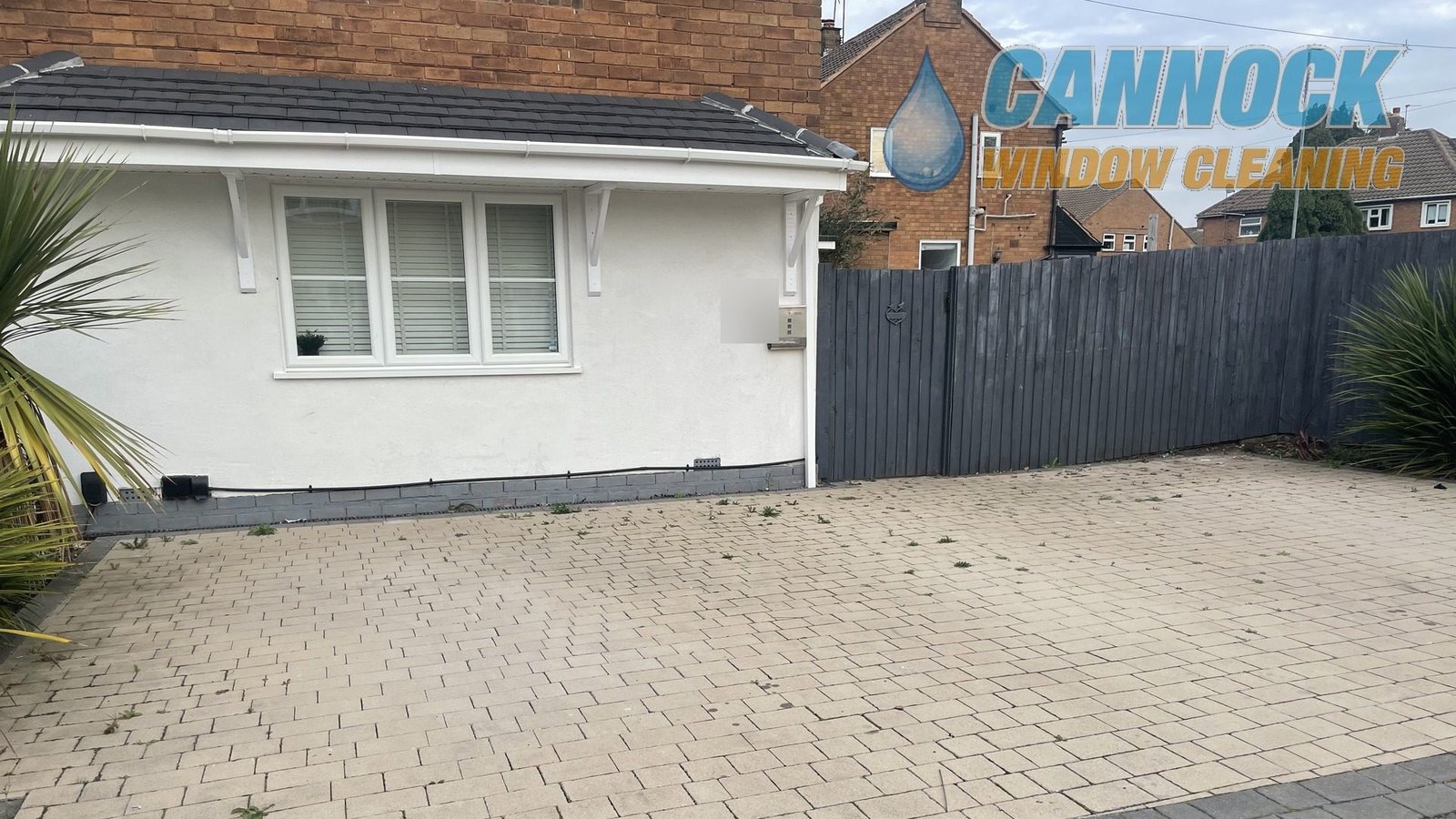 Pale block paving drive with weeds in the joints before cleaning
